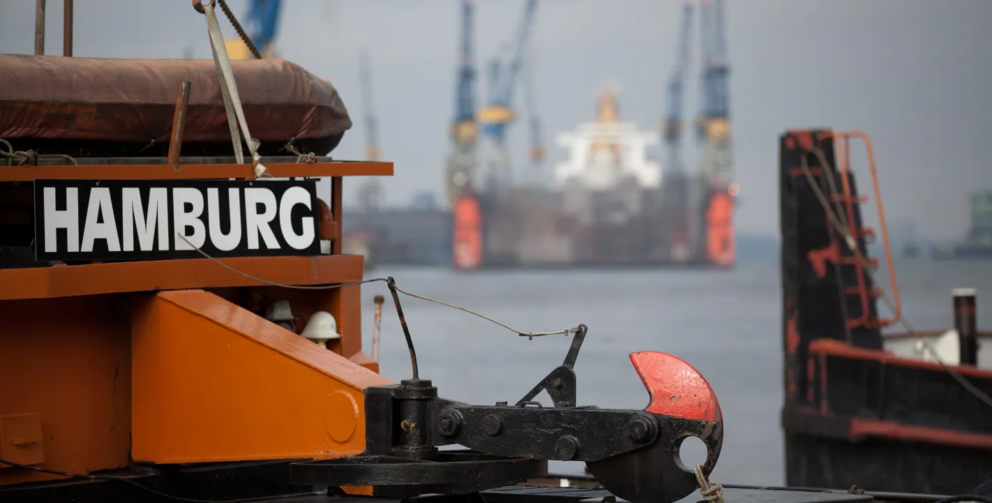 Heck eines orangefarbenen Schiffes mit der Aufschrift „HAMBURG“